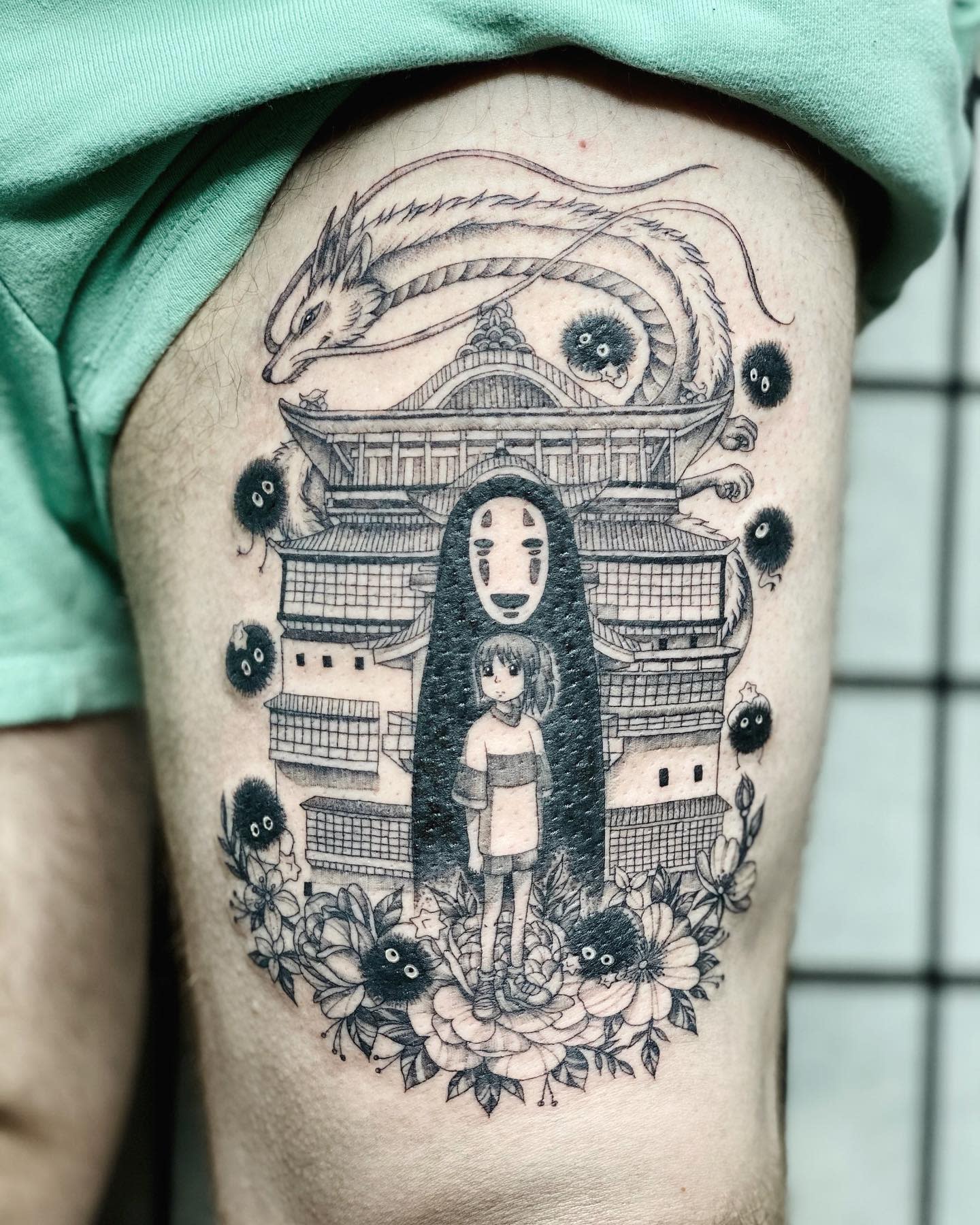 Detailed thigh tattoo featuring a scene from Spirited Away with characters